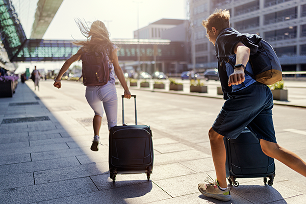 couple running with luggage at airport